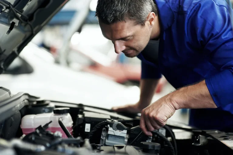Mechanic inspecting car engine repair shop