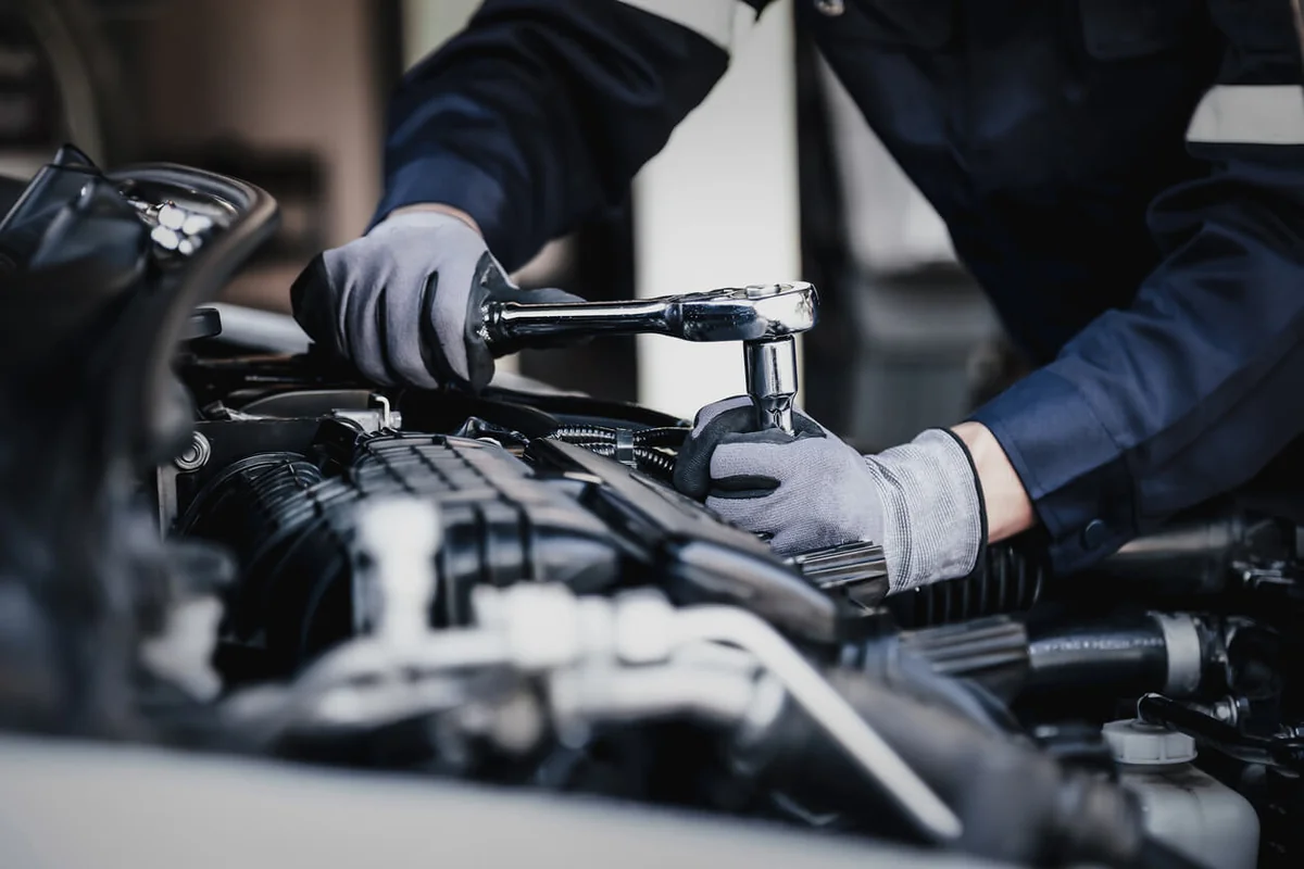 Mechanic working on car engine garage
